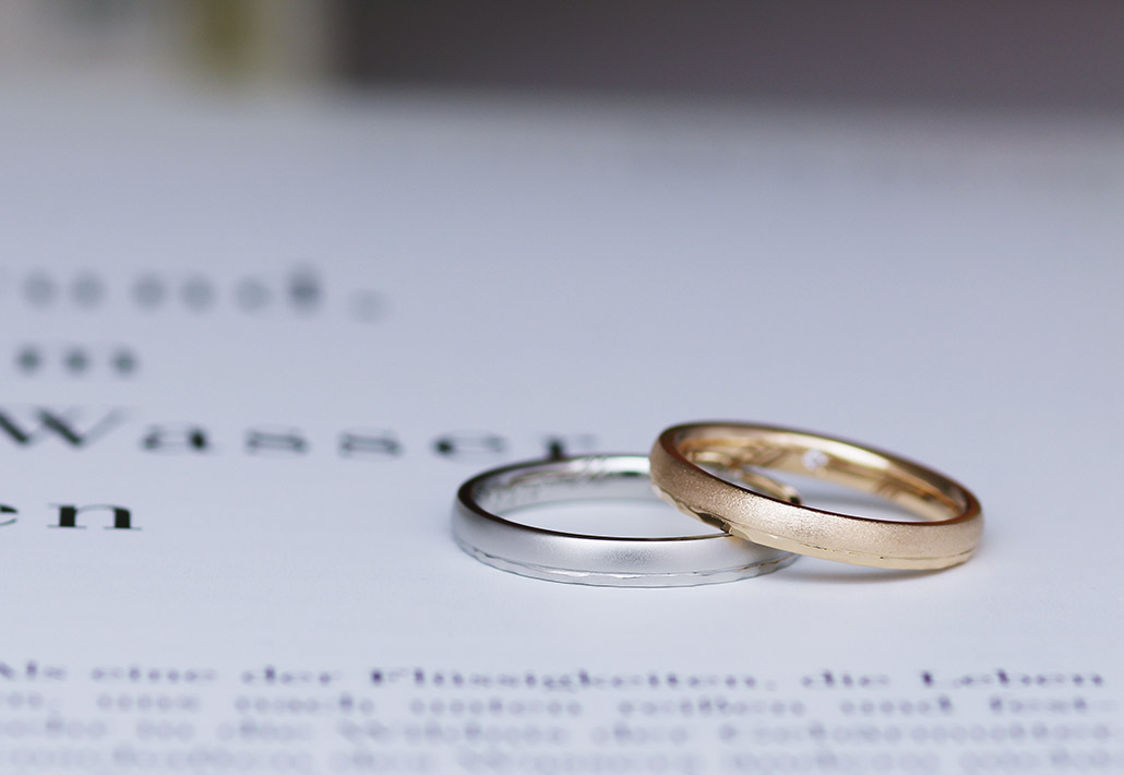 プラチナ素材のメンズリングとピンクゴールド素材の槌目が入った甲丸の結婚指輪（マリッジリング）