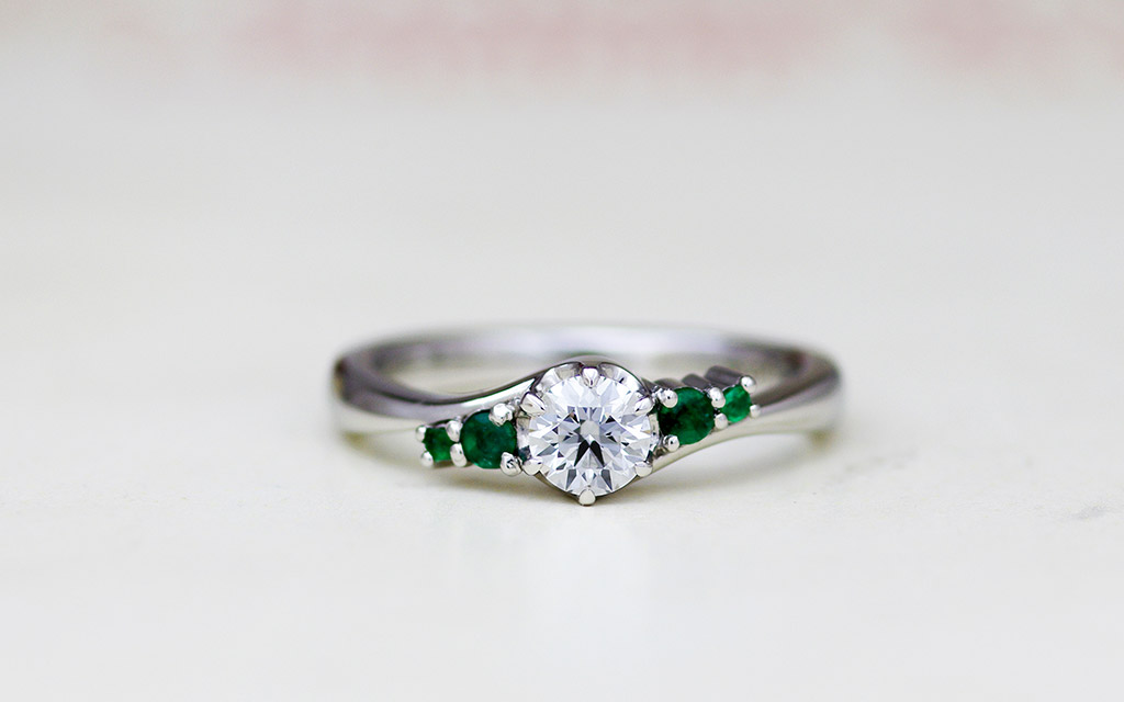 ダイヤモンドとエメラルドの留まったプラチナ製の婚約指輪（エンゲージリング）