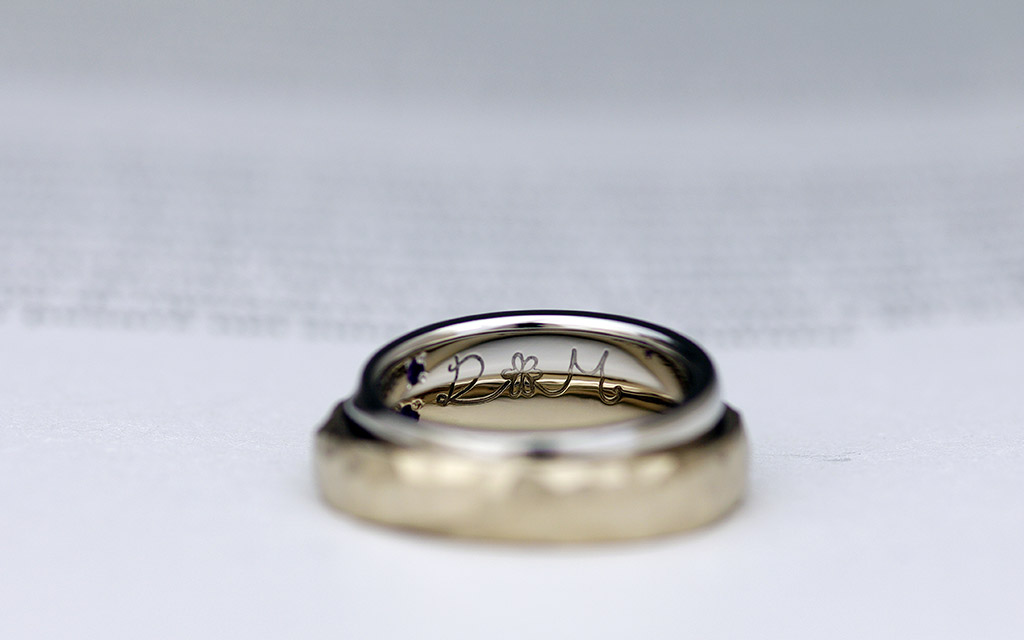 手描きのオリジナルデザインが刻印されたプラチナとゴールドの結婚指輪（マリッジリング）