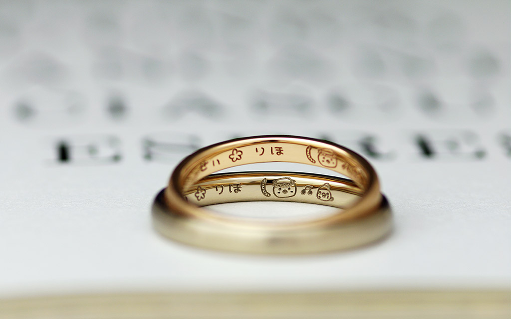 かわいいイラストが刻印されたゴールドの結婚指輪（マリッジリング）