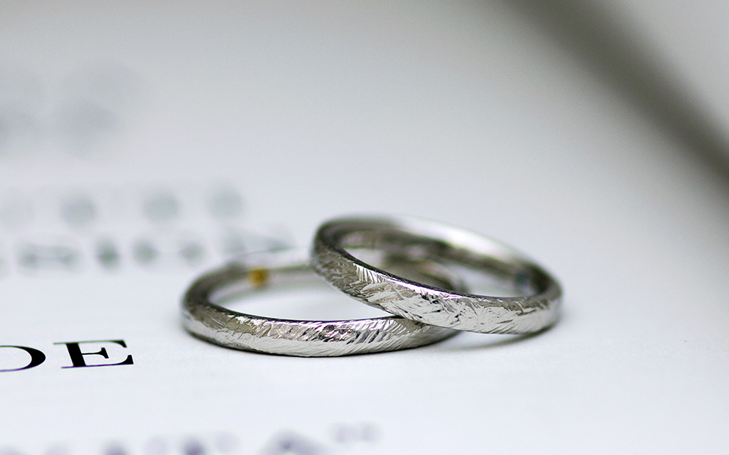 プラチナで作られた個性的なテクスチャーのクラフト感ある結婚指輪（マリッジリング）