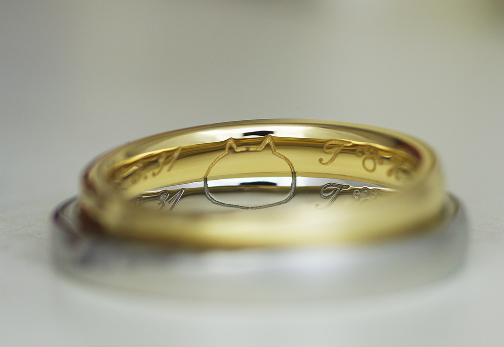 シンプルでかわいい猫のシルエットが刻印されたプラチナとゴールドの結婚指輪