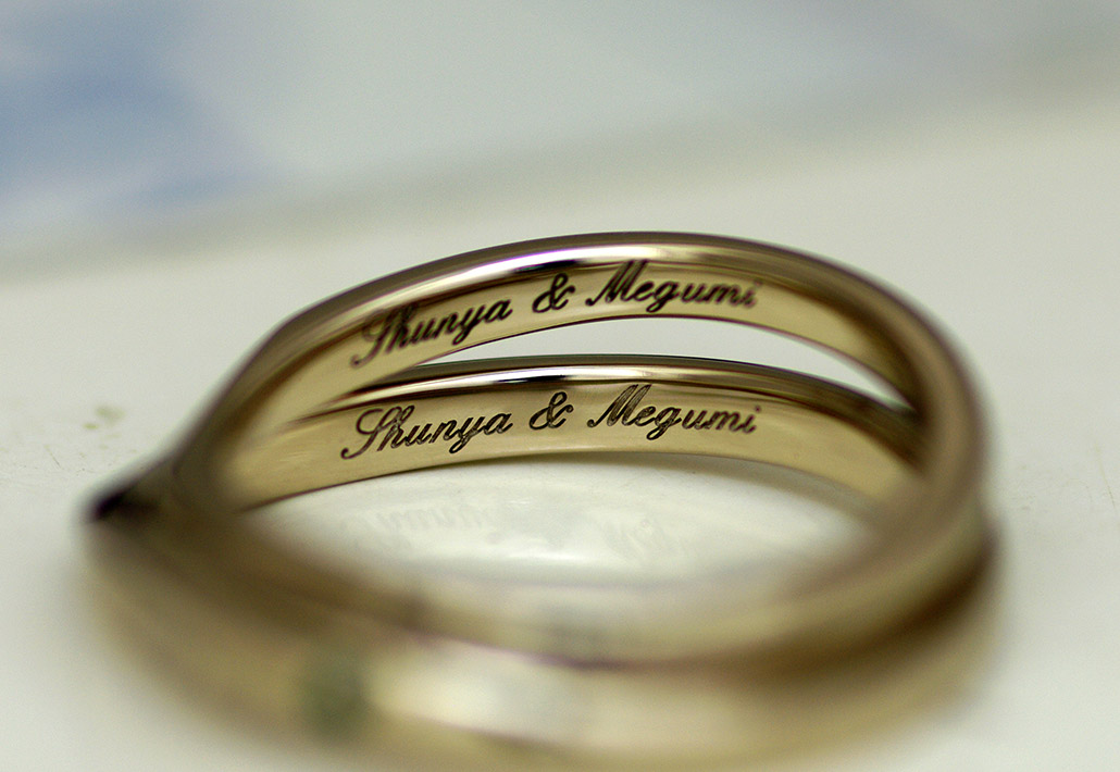 筆記体で刻印した名前が入ったゴールドの結婚指輪（マリッジリング）