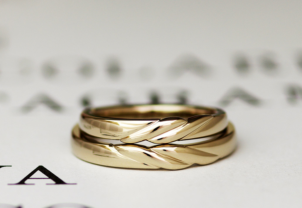 ブライダルジュエリーで人気の高いひねりのデザインが入ったゴールドの結婚指輪（マリッジリング）