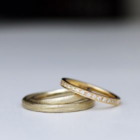 ぼこぼこ、ざらざらとした質感が特徴の結婚指輪とエタニティデザインの婚約指輪