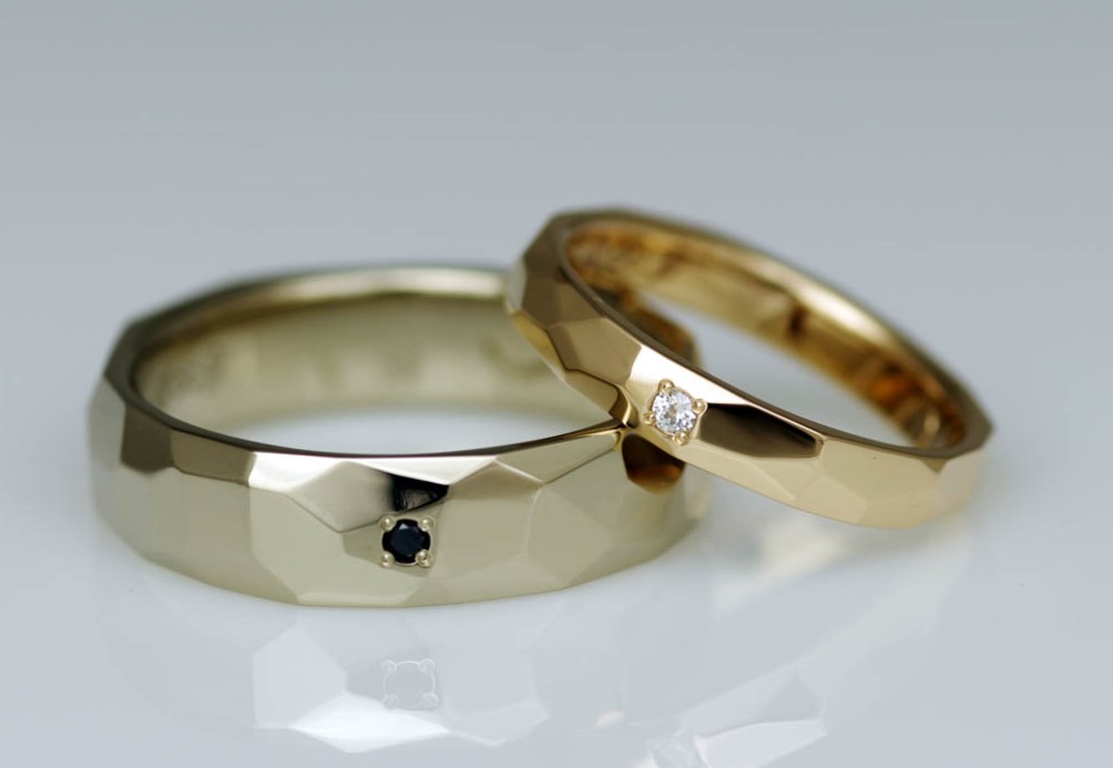 無色透明なダイヤモンドと色味がかっこいいブラックダイヤモンドが留まったゴールドの結婚指輪（マリッジリング）