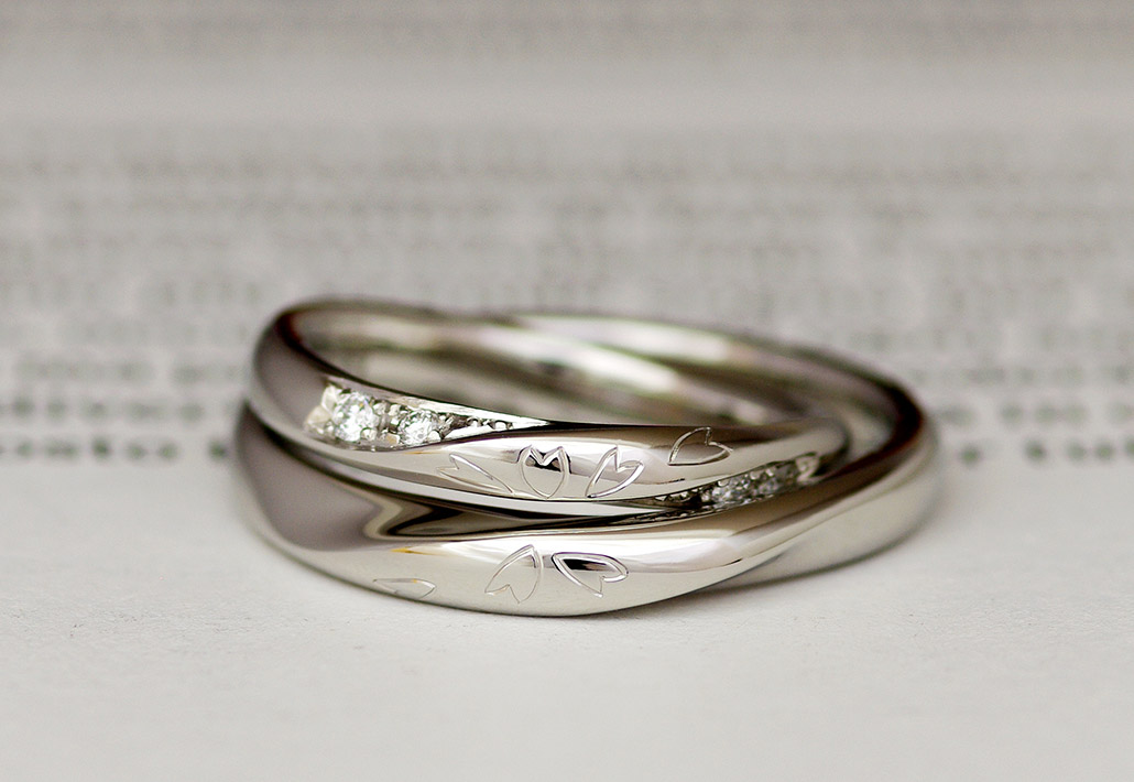 合わせると桜の手彫り彫刻のデザインが入ったプラチナ製の手作り結婚指輪（マリッジリング）