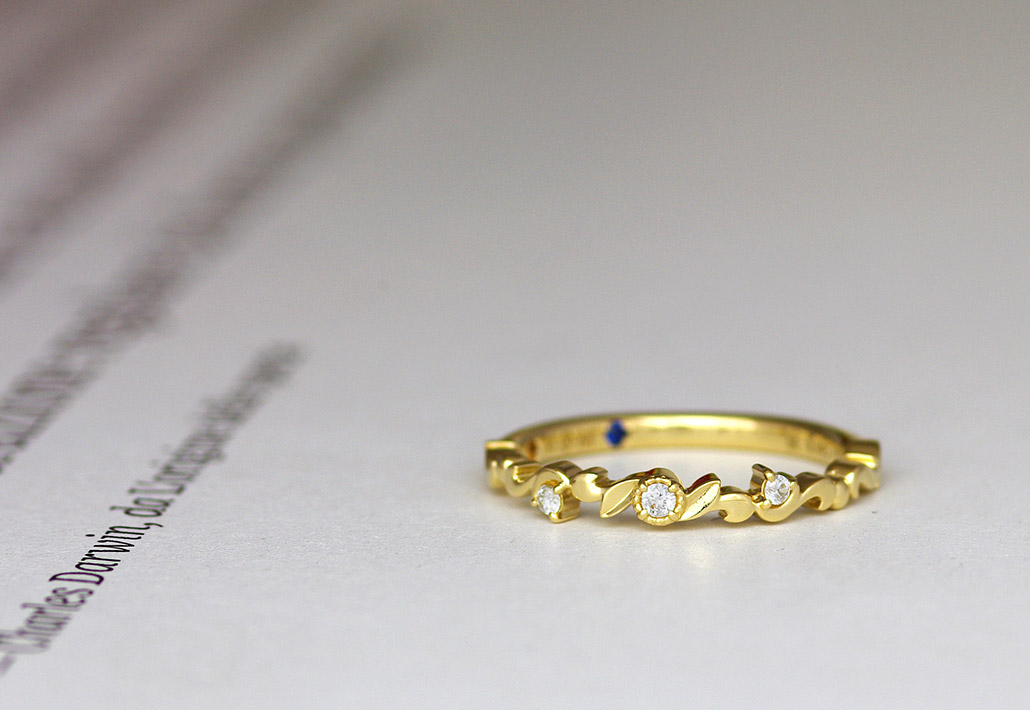 月と太陽をイメージしてデザインされたイエローゴールドの婚約指輪（エンゲージリング）