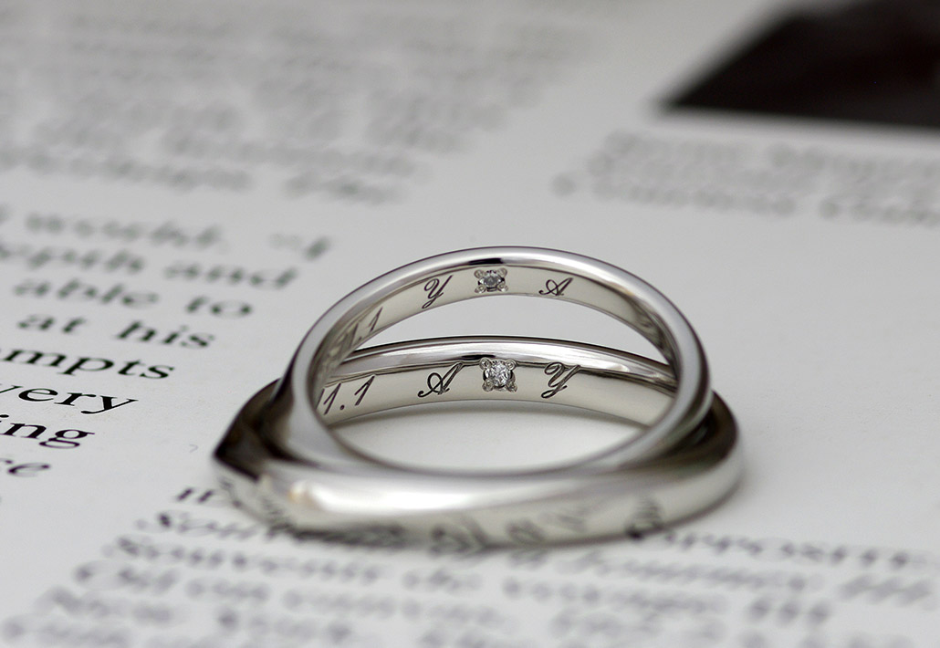 イニシャルの刻印とダイヤモンドがセッティングされたプラチナ製の結婚指輪（マリッジリング）