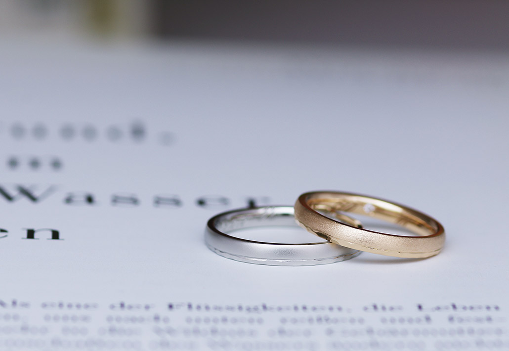 プラチナ素材のメンズリングとピンクゴールド素材の槌目が入った甲丸の結婚指輪（マリッジリング）