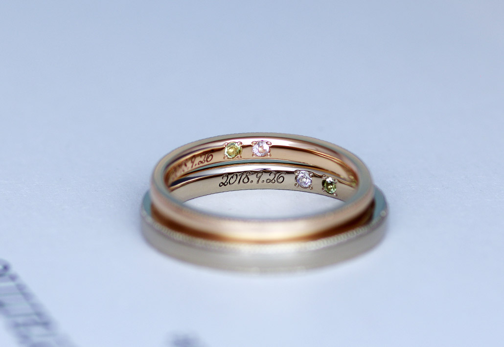 記念日の刻印と誕生石が留まったオーダーメイドの結婚指輪（マリッジリング）