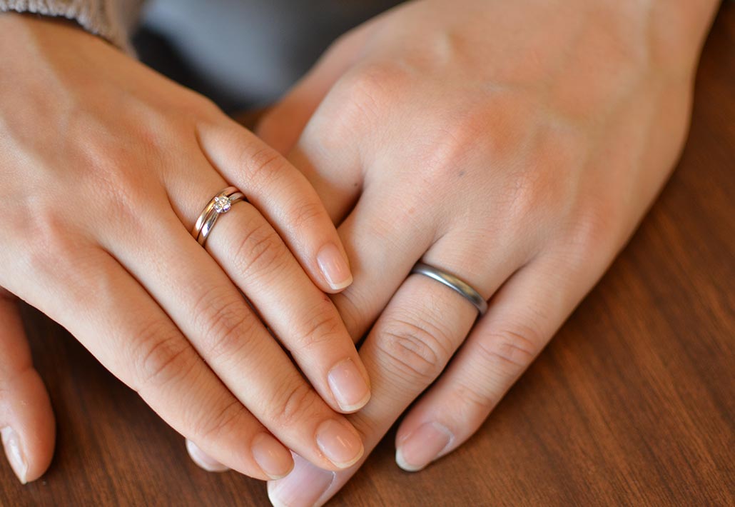 重なるおふたりの手と結婚指輪
